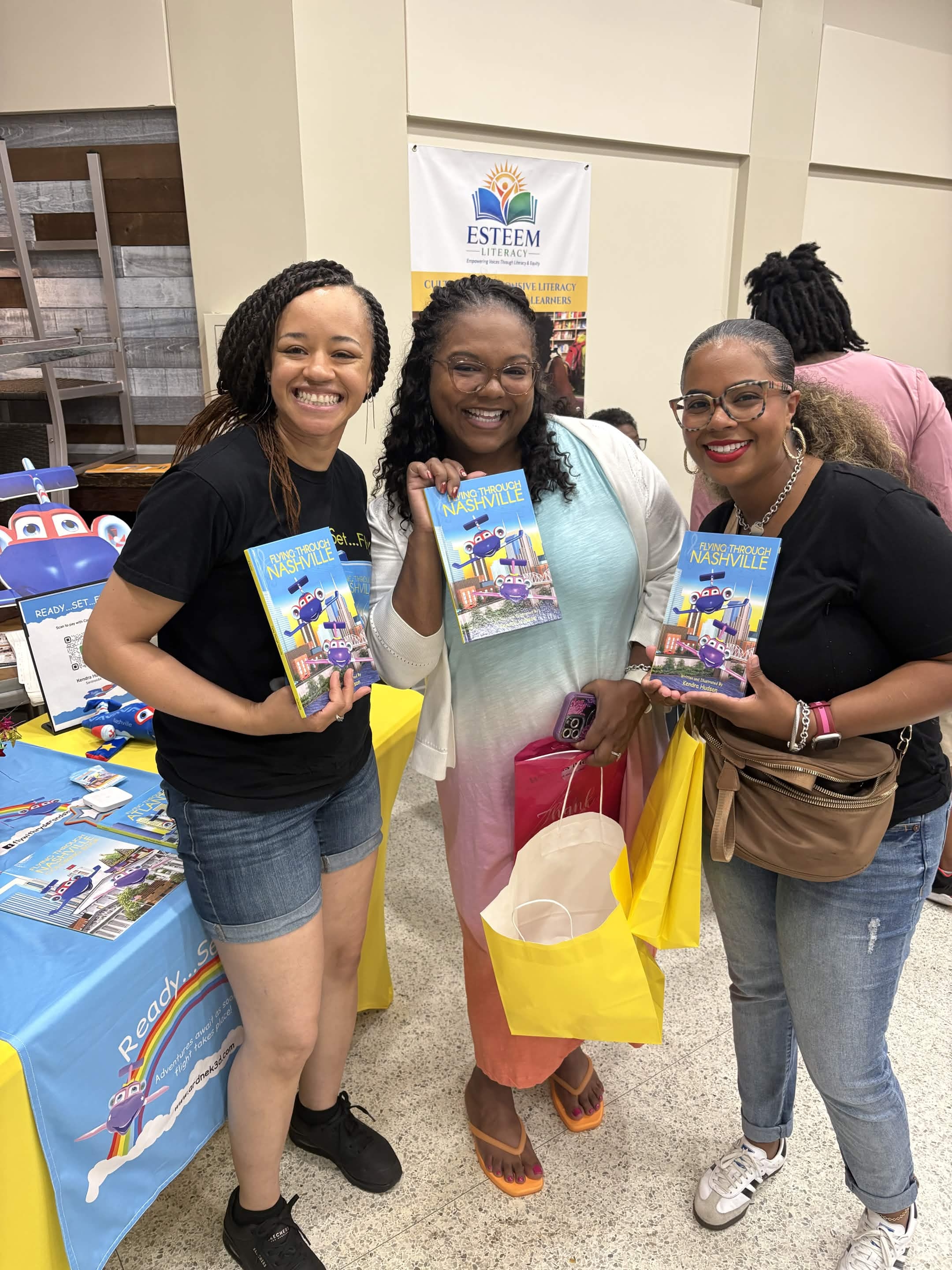 Community members holding Flying Through Nashville books at a Fruit of the Vine event